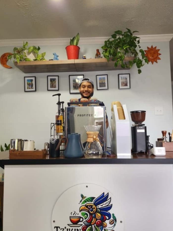 Allan with professional coffee setup at Tz'ikin Cafe