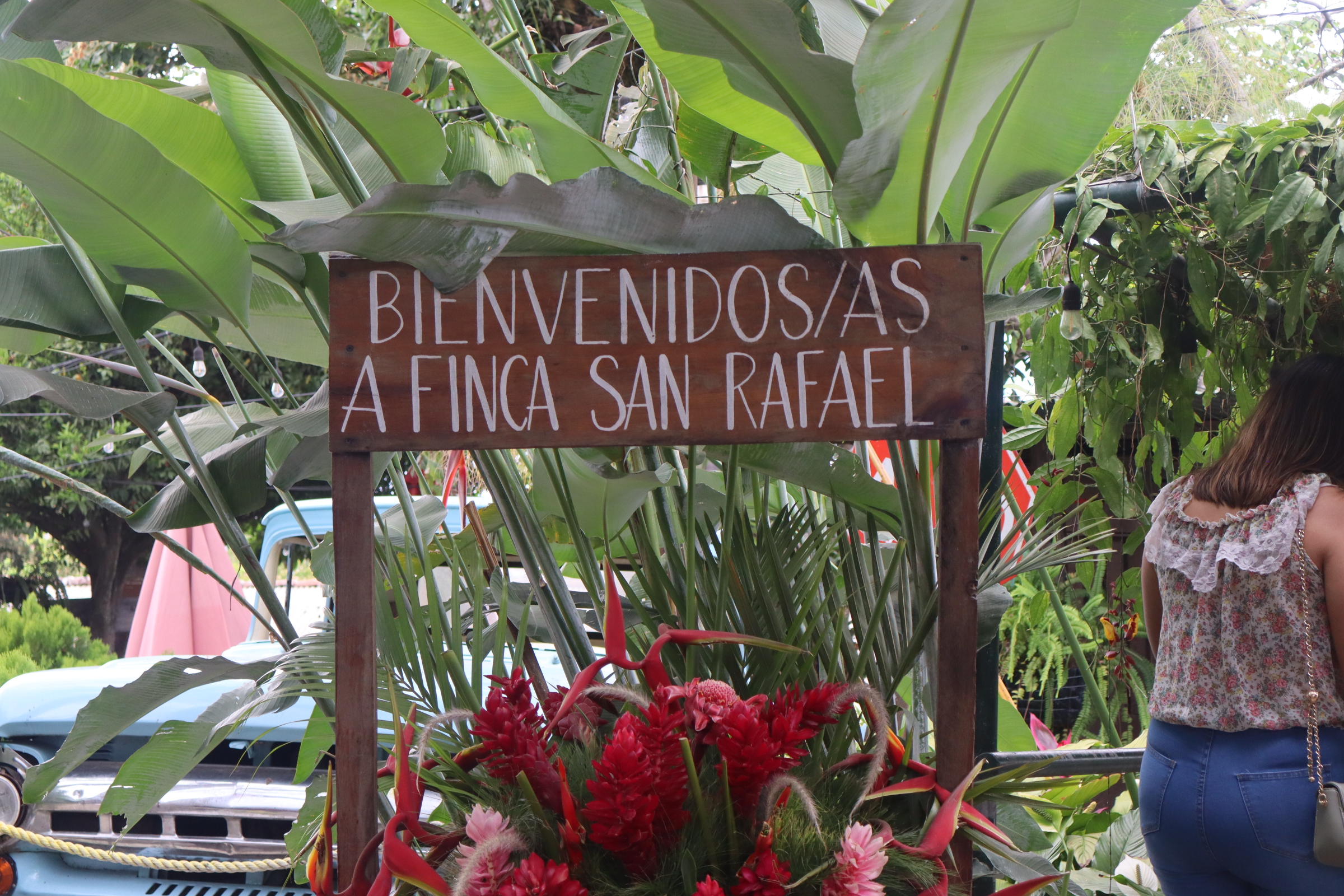 Welcome sign at Finca San Rafael surrounded by tropical plants